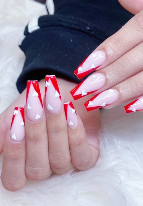 Woman with heart pattern nails design. Manicure. Nail salon. Classic bridal nail design. Valentine nails